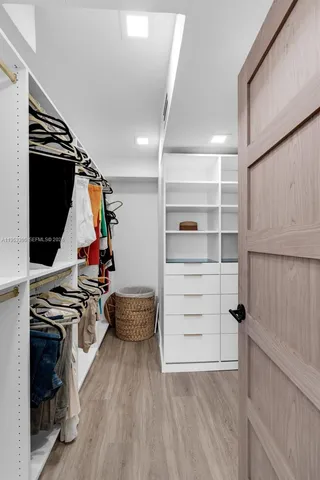 a view of walk in closet with clothes
