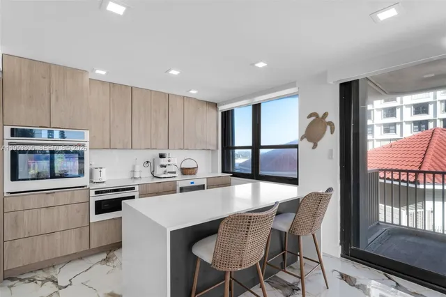a kitchen with kitchen island a stove a table and chairs in it