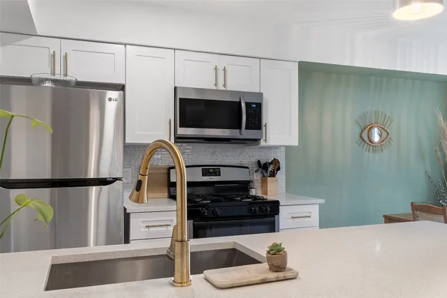 a kitchen with stainless steel appliances a refrigerator a stove a microwave and cabinets