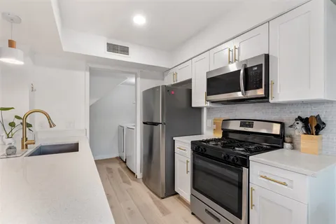 a kitchen with stainless steel appliances a stove microwave and a refrigerator