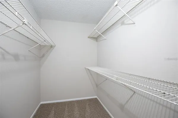 an empty room with closet and a ceiling fan