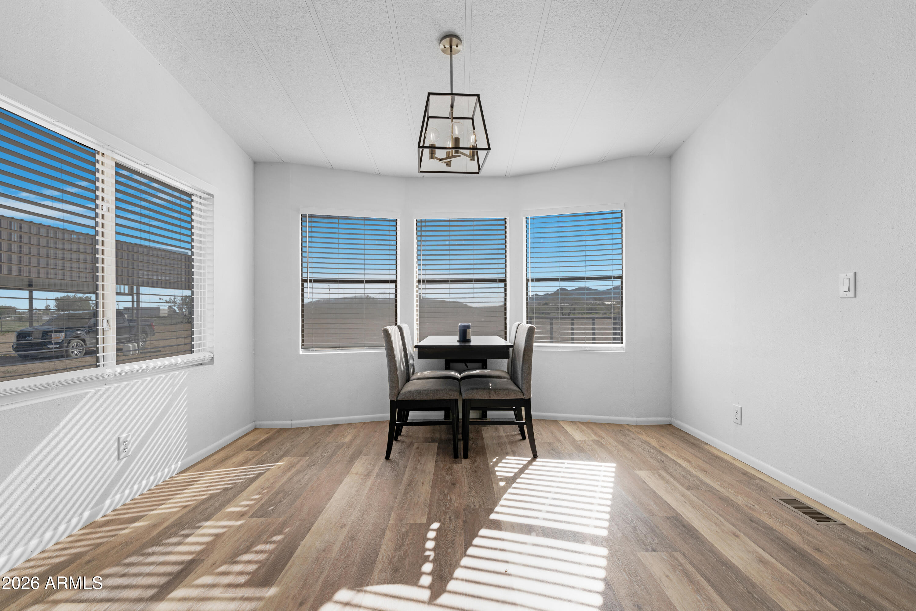 53925 West Stallion Road Maricopa, AZ 85139 - Photo 11 of 46 a view of a room with wooden floor windows and wooden floor
