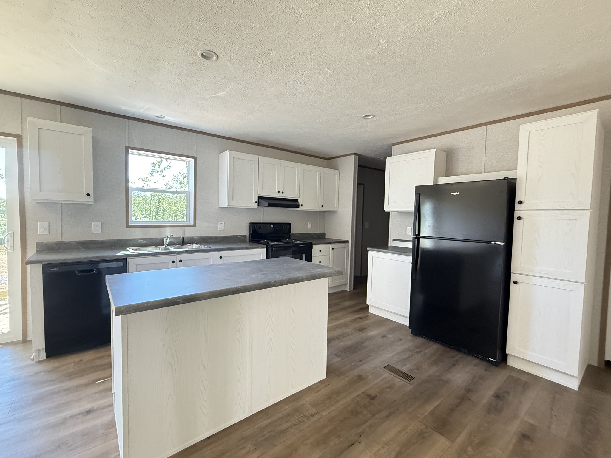 467 Woodland Road Hohenwald, TN 38462 - Photo 1 of 20 a kitchen with kitchen island granite countertop a refrigerator stove top oven and sink