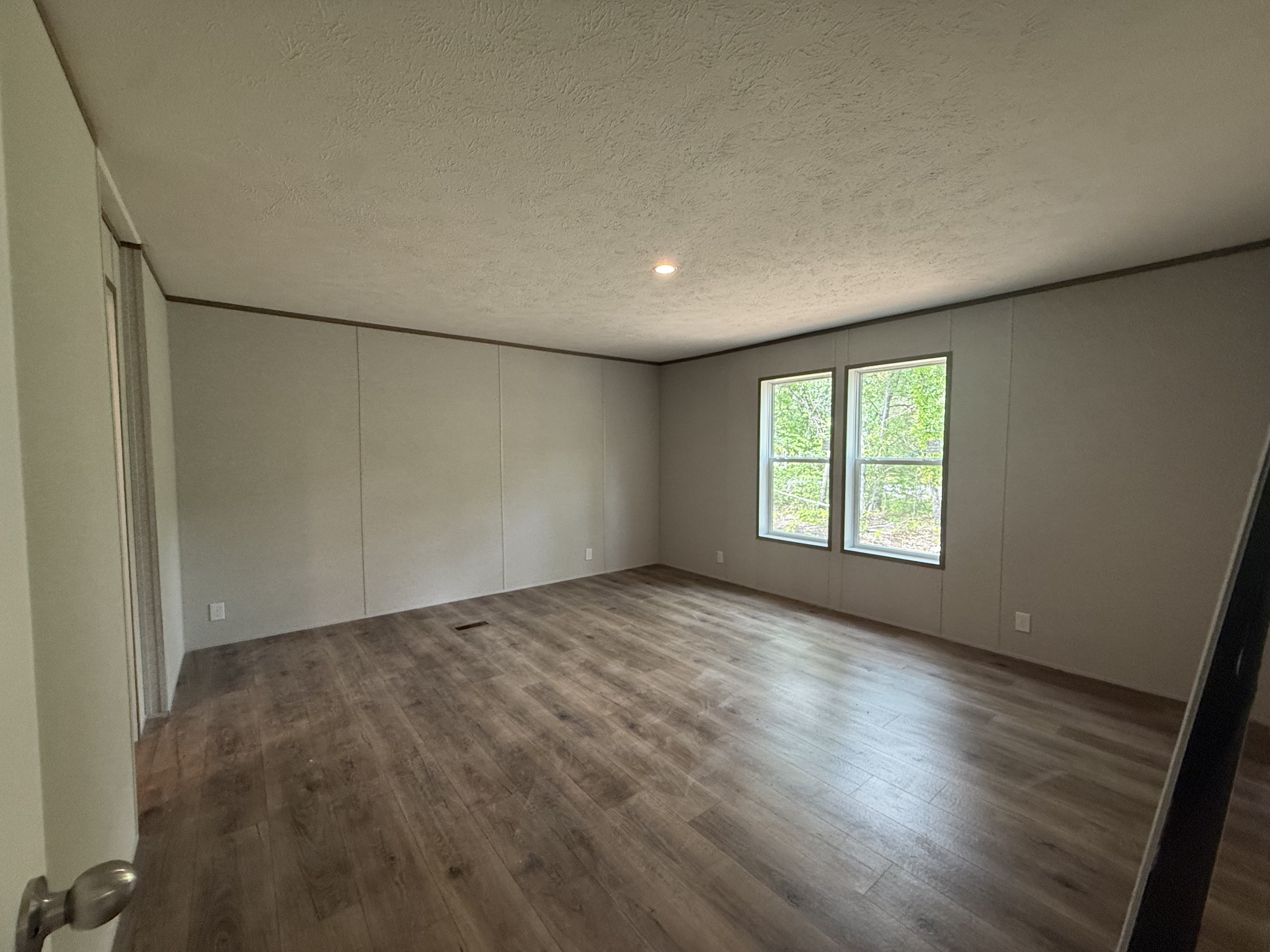 467 Woodland Road Hohenwald, TN 38462 - Photo 13 of 20 an empty room with wooden floor and windows