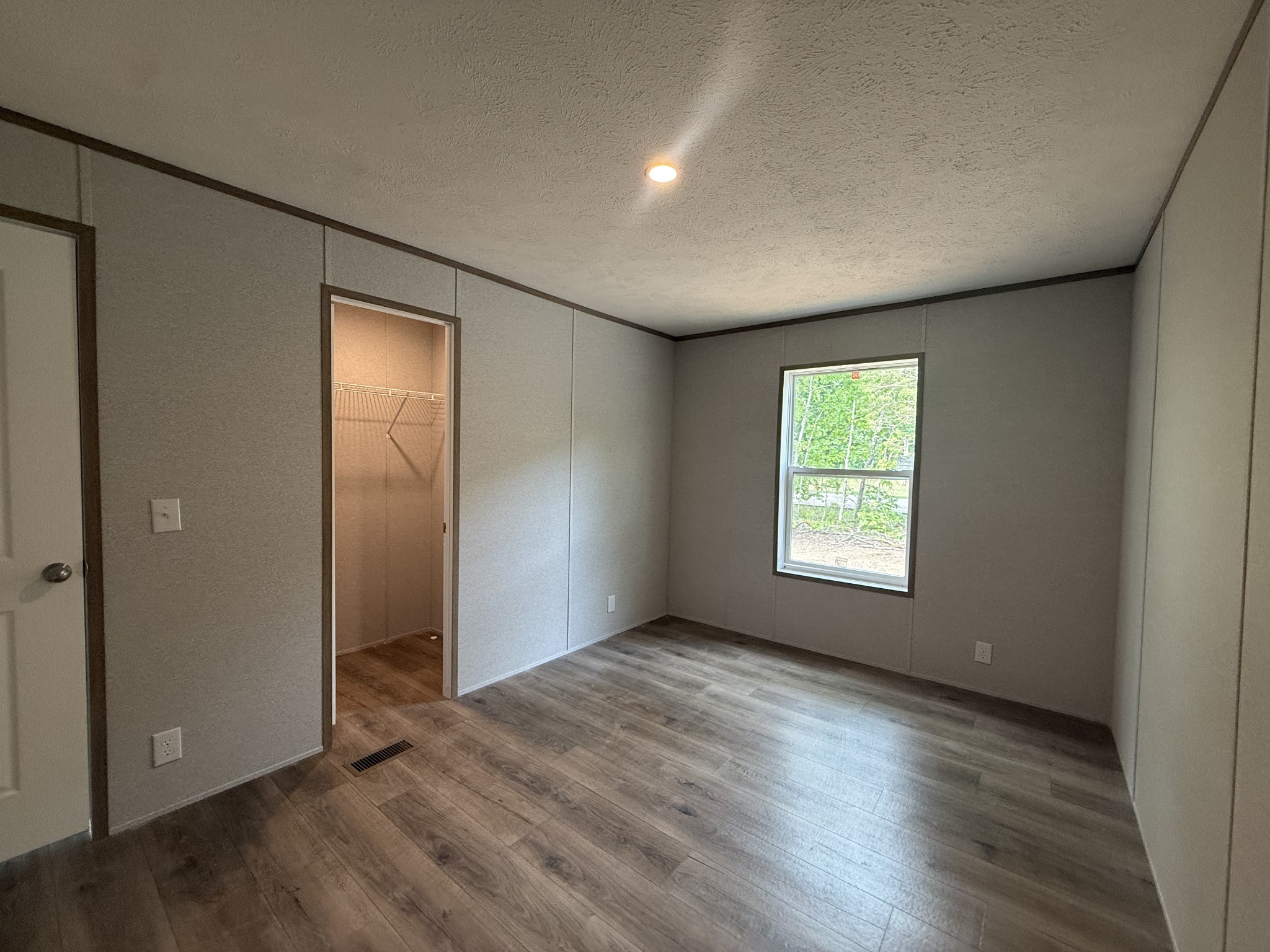 467 Woodland Road Hohenwald, TN 38462 - Photo 14 of 20 an empty room with wooden floor and windows