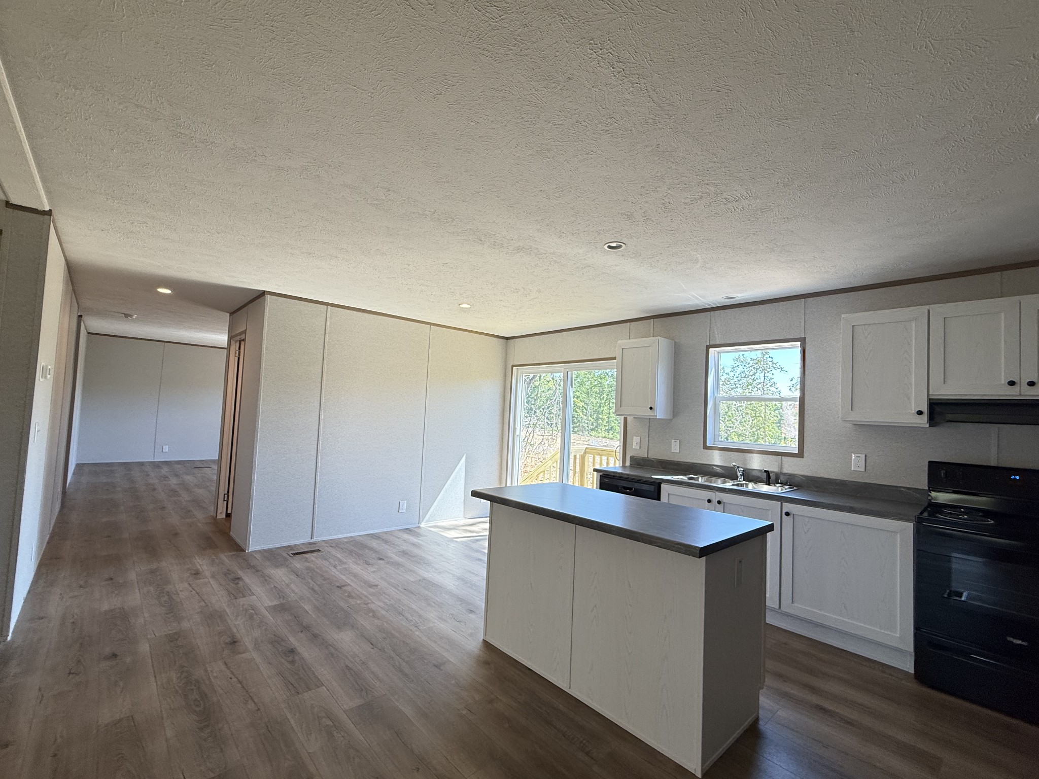 467 Woodland Road Hohenwald, TN 38462 - Photo 4 of 20 a kitchen with granite countertop a sink cabinets and stainless steel appliances