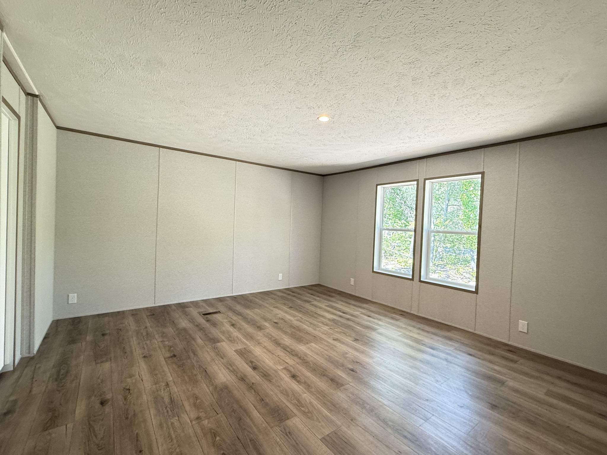 467 Woodland Road Hohenwald, TN 38462 - Photo 5 of 20 an empty room with wooden floor and windows