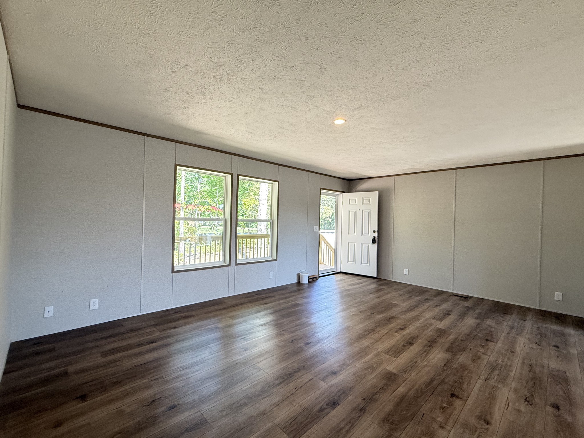 467 Woodland Road Hohenwald, TN 38462 - Photo 6 of 20 an empty room with wooden floor and windows