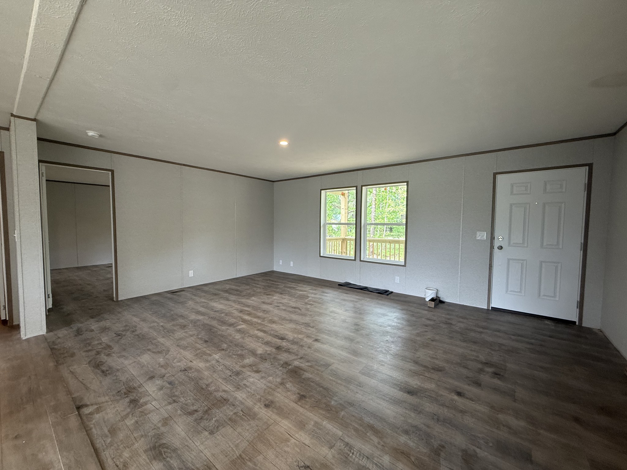 467 Woodland Road Hohenwald, TN 38462 - Photo 7 of 20 an empty room with wooden floor and windows