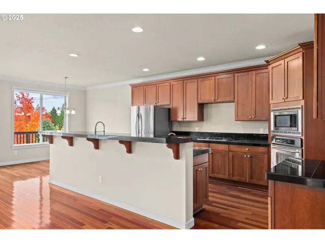a kitchen with granite countertop a sink stove and refrigerator
