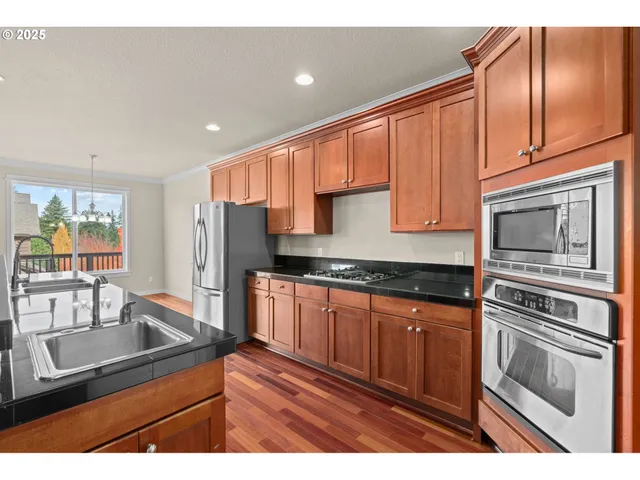 a kitchen with stainless steel appliances granite countertop a sink stove and refrigerator