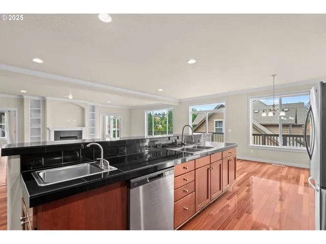 a kitchen with stainless steel appliances granite countertop a stove a sink and a refrigerator