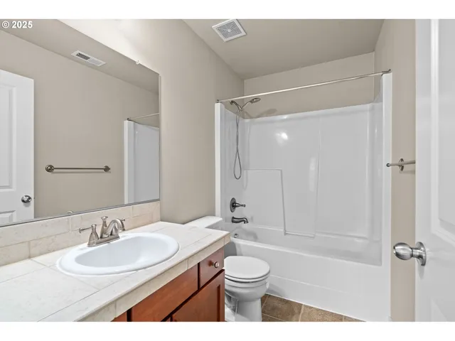 a bathroom with a sink double vanity granite tub and a mirror