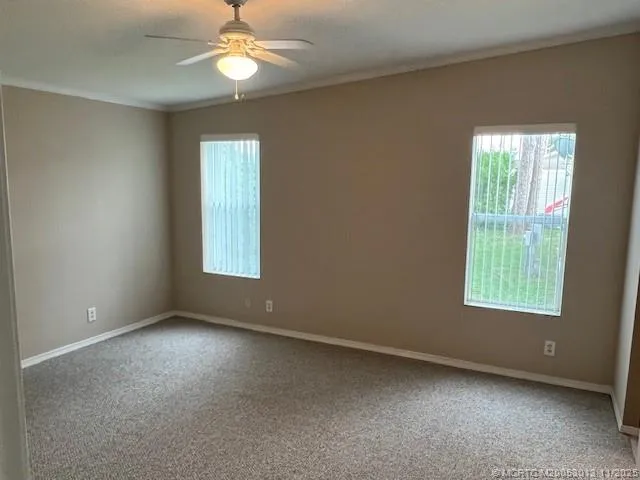 an empty room with closet and a ceiling fan