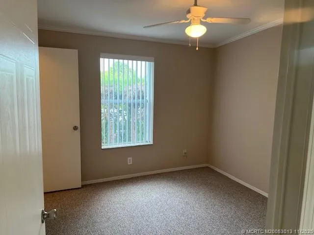 an empty room with a window and a fan