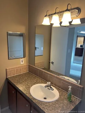 a bathroom with a granite countertop sink and a mirror