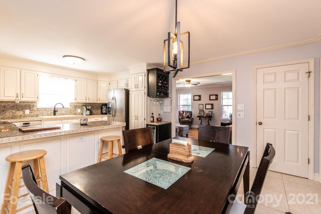 1002 4th Street Northeast Conover, NC 28613 - Photo 12 of 41 a open kitchen with stainless steel appliances granite countertop a stove a sink a dining table and chairs