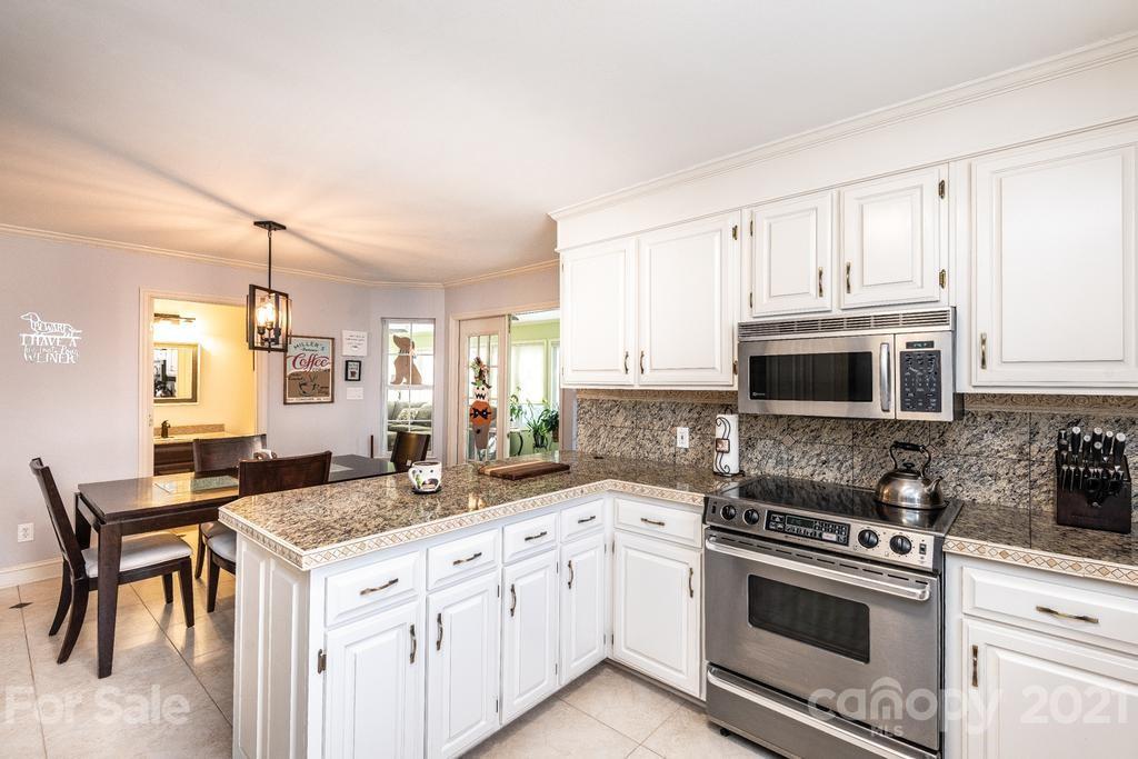 1002 4th Street Northeast Conover, NC 28613 - Photo 13 of 41 a kitchen with granite countertop a sink stove and cabinets