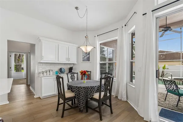 a kitchen with stainless steel appliances a kitchen island a stove a refrigerator a sink dishwasher a oven with a dining table and chairs