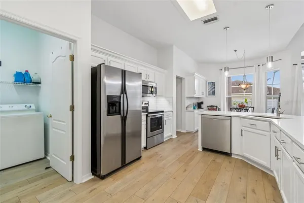 a dining room with furniture a chandelier and wooden floor