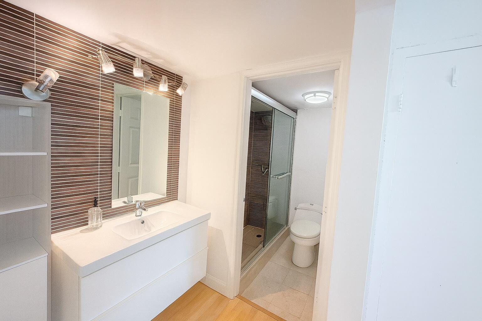 a bathroom with a double vanity sink toilet and shower