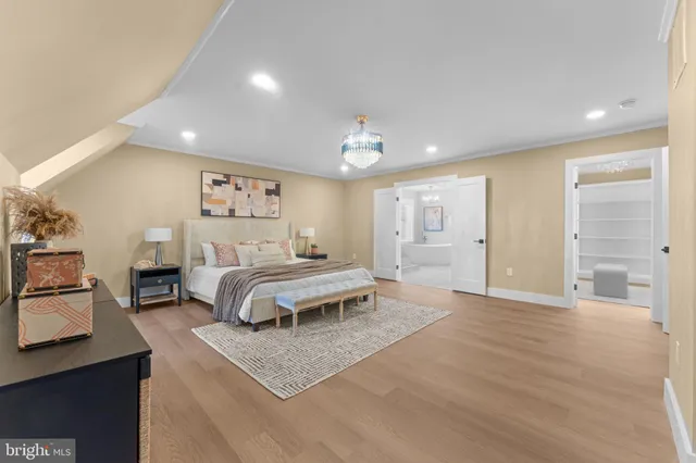 a spacious bedroom with a bed a table and painting