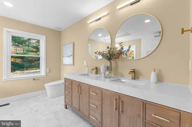 a spacious bathroom with a granite countertop double vanity mirror and a bathtub