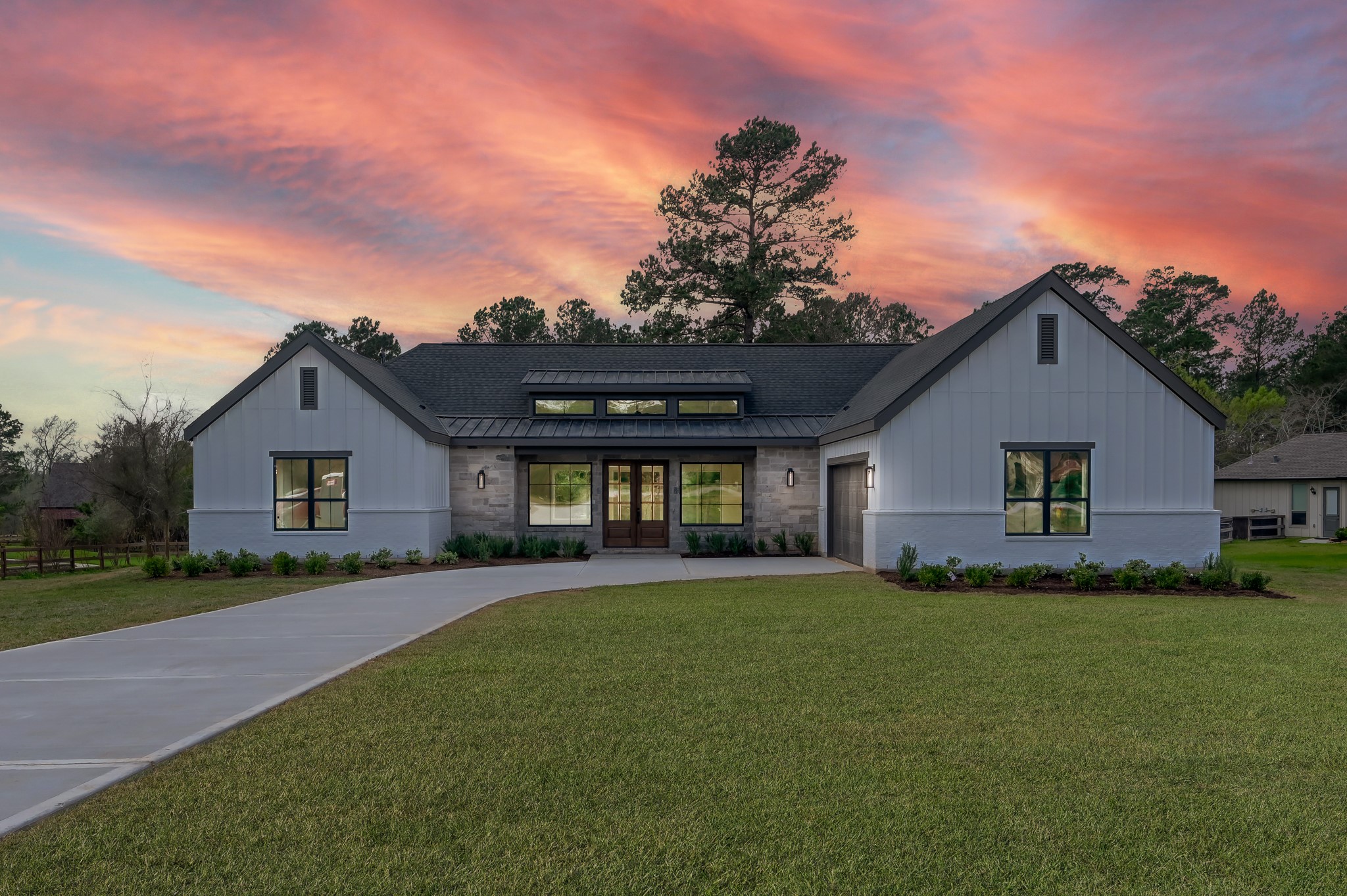 14742 Turquoise Trail Willis, TX 77378 - Photo 43 of 48 Beautiful twilight view highlighting the home’s dramatic rooflines and warm exterior lighting. The evening sky provides a striking backdrop for this thoughtfully designed custom residence.