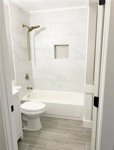 a bathroom with a white toilet and a bathtub