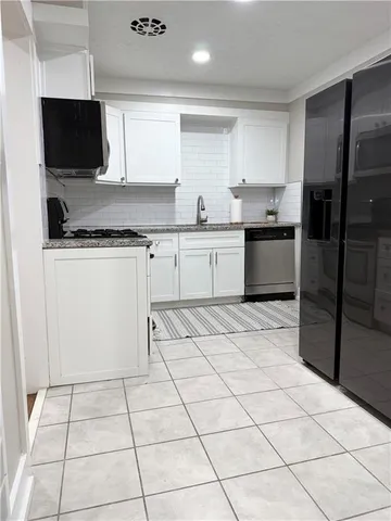 a kitchen with a sink a stove a microwave and cabinets