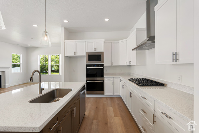 549 North Legend Circle, Unit C/466 Mapleton, UT 84664 - Photo 13 of 39 Kitchen with light wood finished floors, white cabinetry, wall chimney exhaust hood, appliances with stainless steel finishes, and recessed lighting