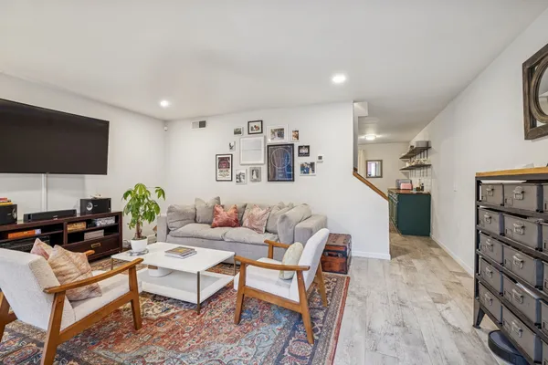 a living room with furniture a flat screen tv and a bookshelf