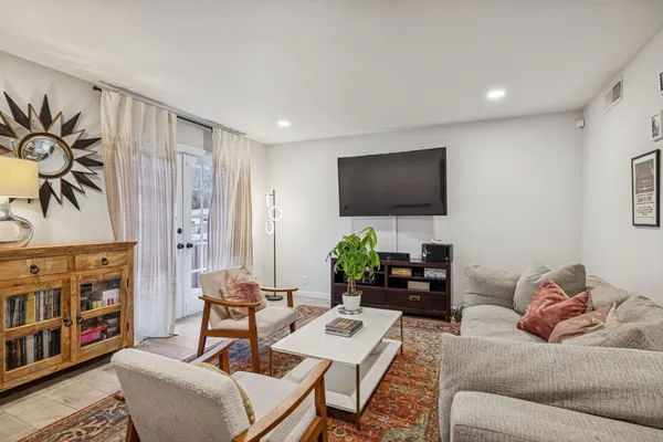 a living room with furniture a dining table and a potted plant