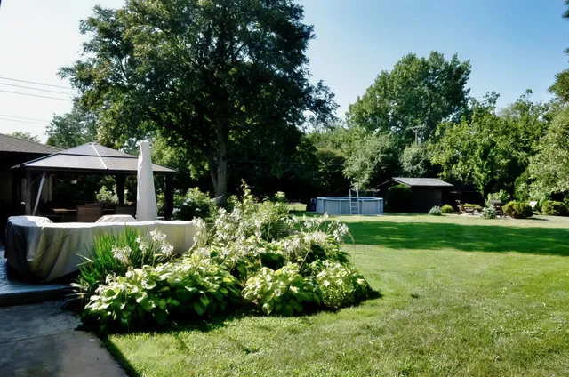 a view of a patio with table and chairs under an umbrella
