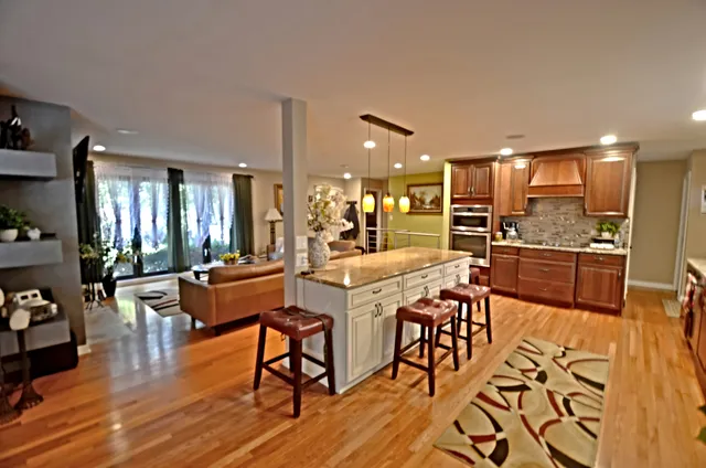 a dining hall with stainless steel appliances a dining table and chairs with wooden floor