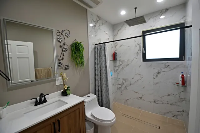 a bathroom with a sink a toilet and shower