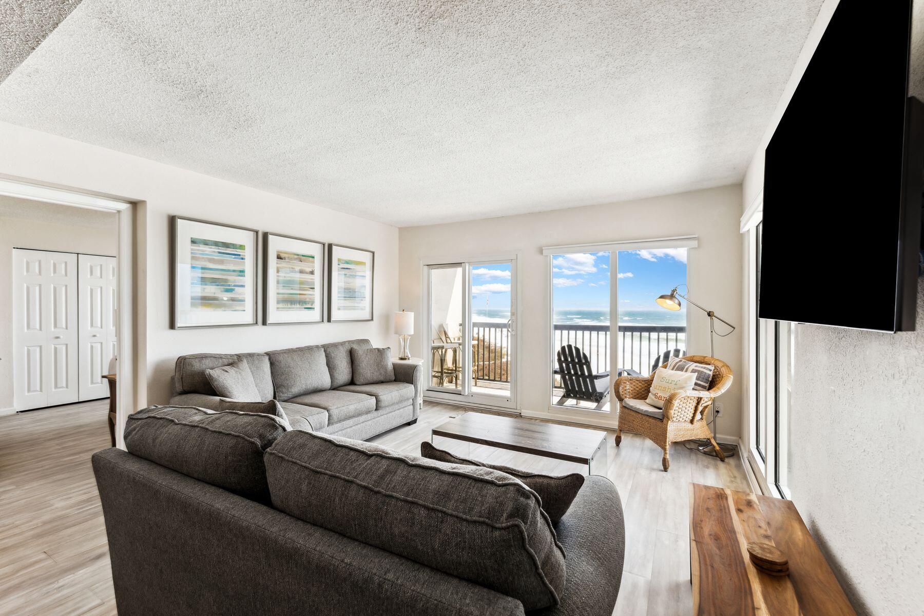 23223 Front Beach Road, Unit B2405 Panama City Beach, FL 32413 - Photo 4 of 28 a living room with furniture a large window and a flat screen tv