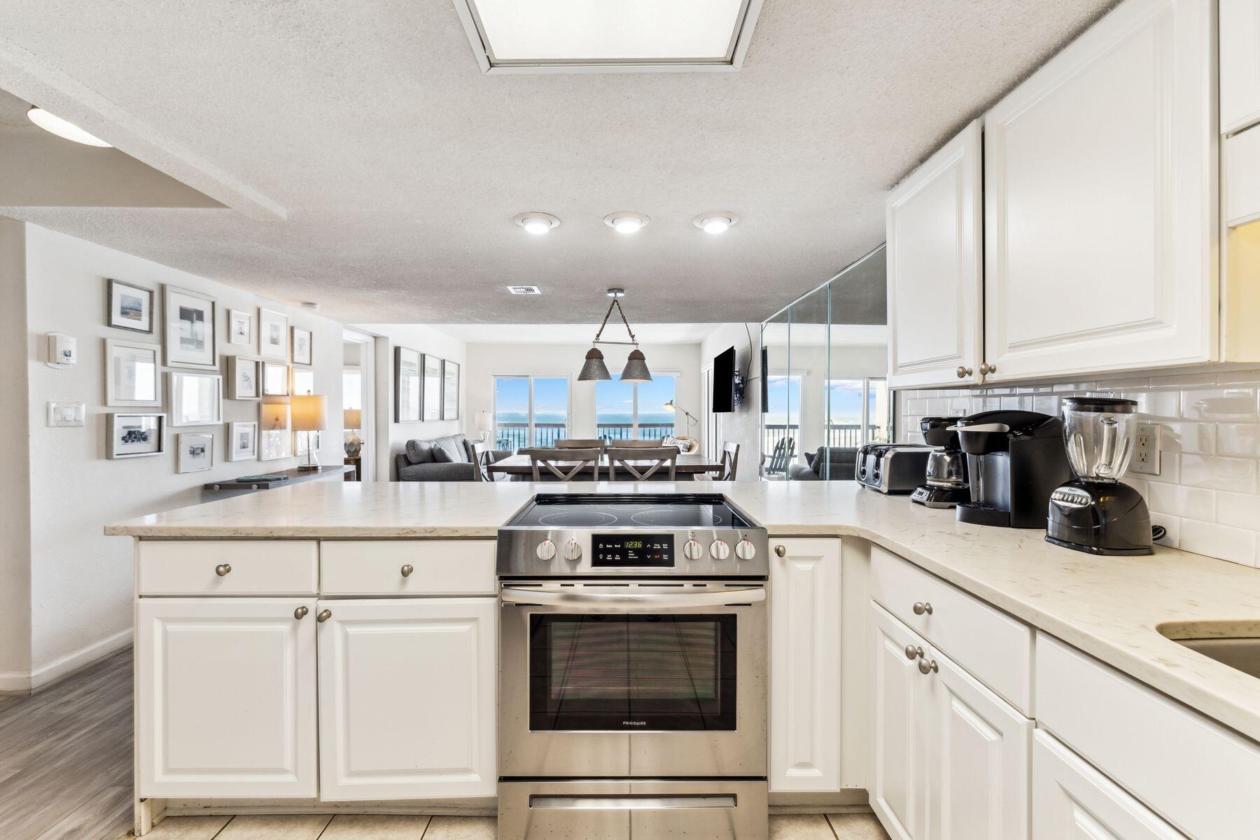 23223 Front Beach Road, Unit B2405 Panama City Beach, FL 32413 - Photo 7 of 28 a kitchen with stainless steel appliances granite countertop a stove a sink and white cabinets