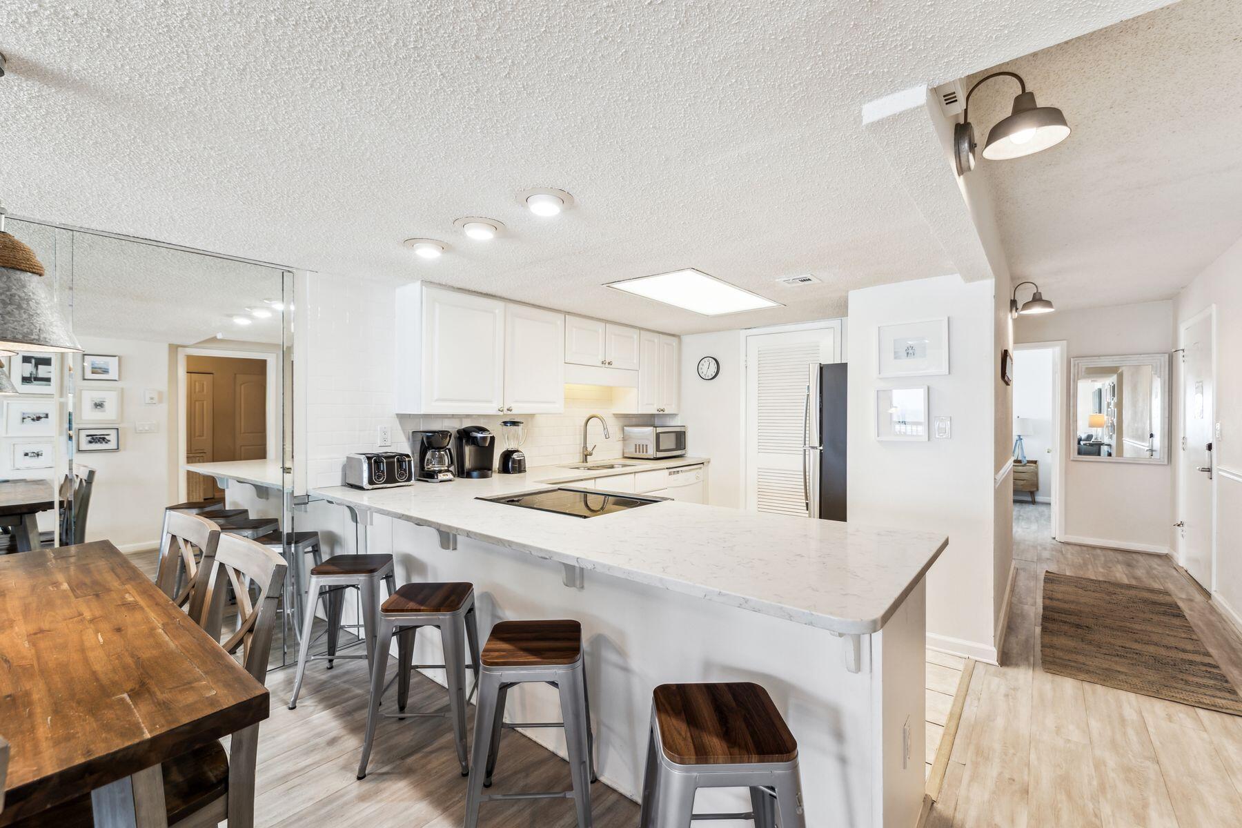 23223 Front Beach Road, Unit B2405 Panama City Beach, FL 32413 - Photo 8 of 28 a kitchen with stainless steel appliances a table and chairs in it