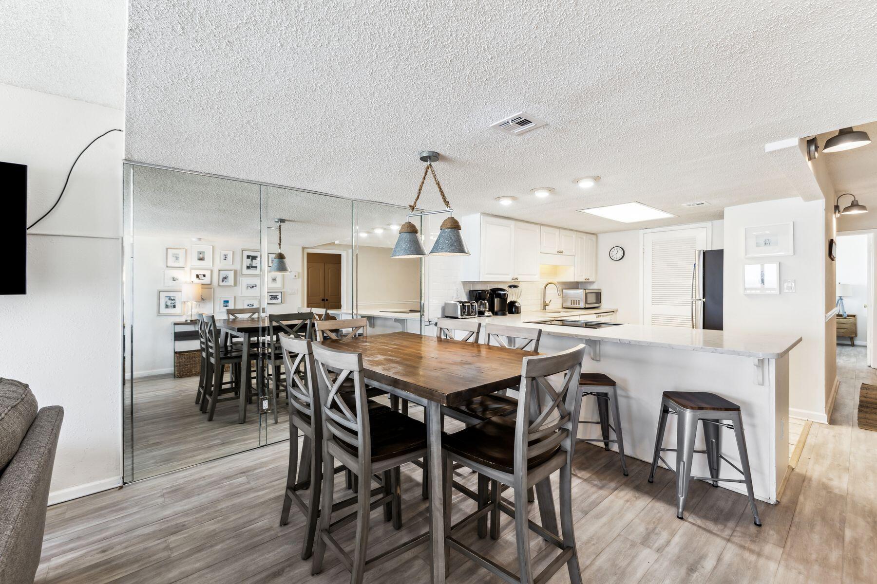 23223 Front Beach Road, Unit B2405 Panama City Beach, FL 32413 - Photo 9 of 28 a view of a dining room with furniture and wooden floor