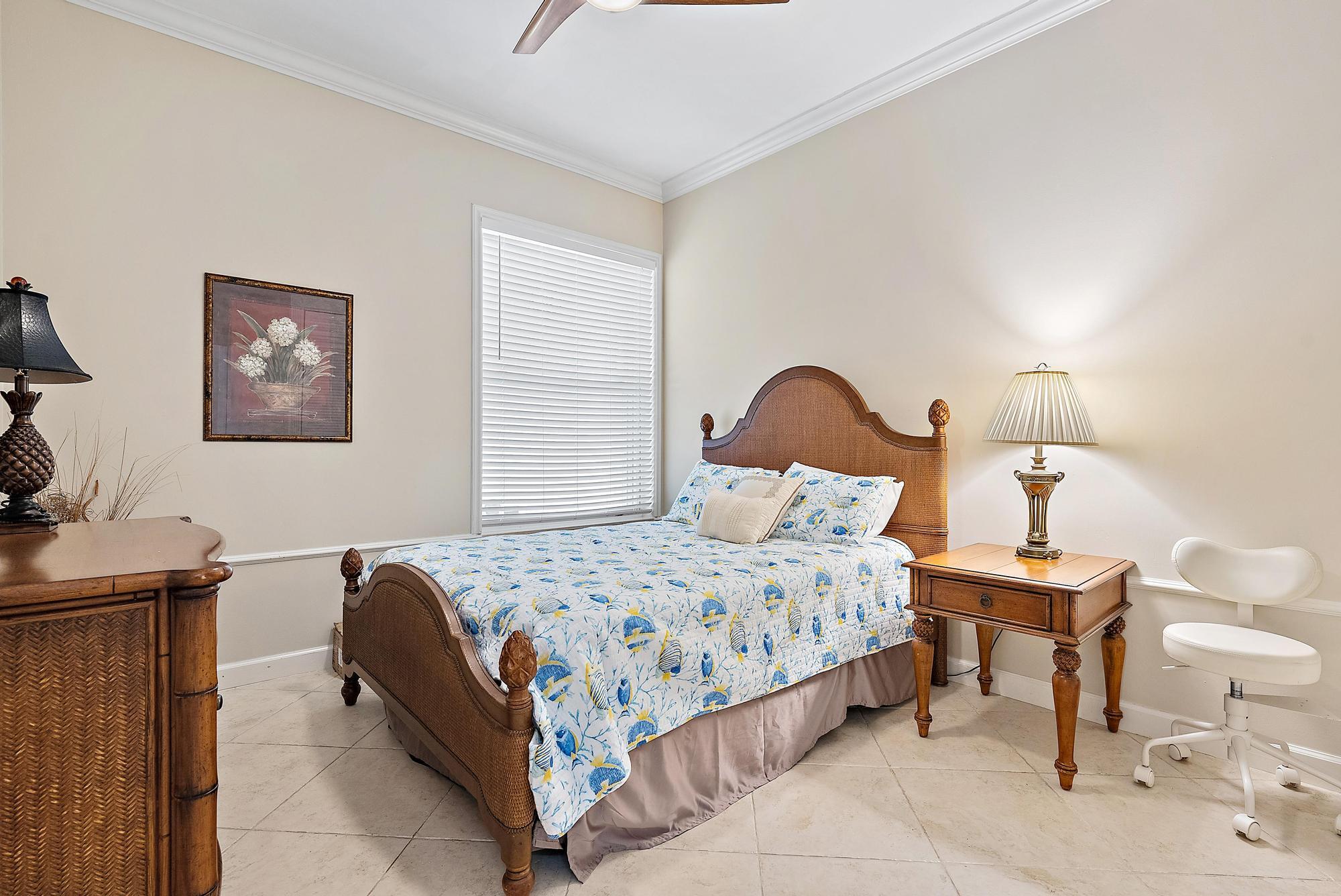 124 South Hampton Drive Jupiter, FL 33458 - Photo 18 of 39 a bedroom with a bed and a lamp on table