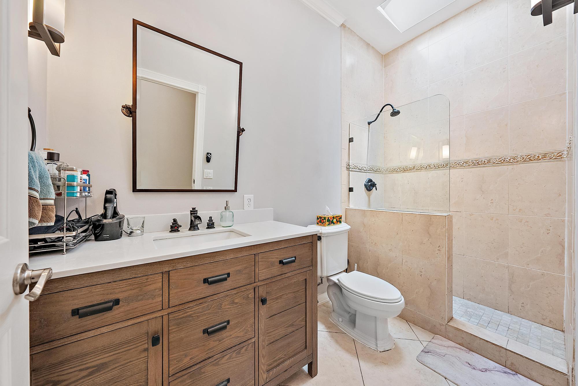 124 South Hampton Drive Jupiter, FL 33458 - Photo 19 of 39 a bathroom with a toilet a sink a mirror and shower