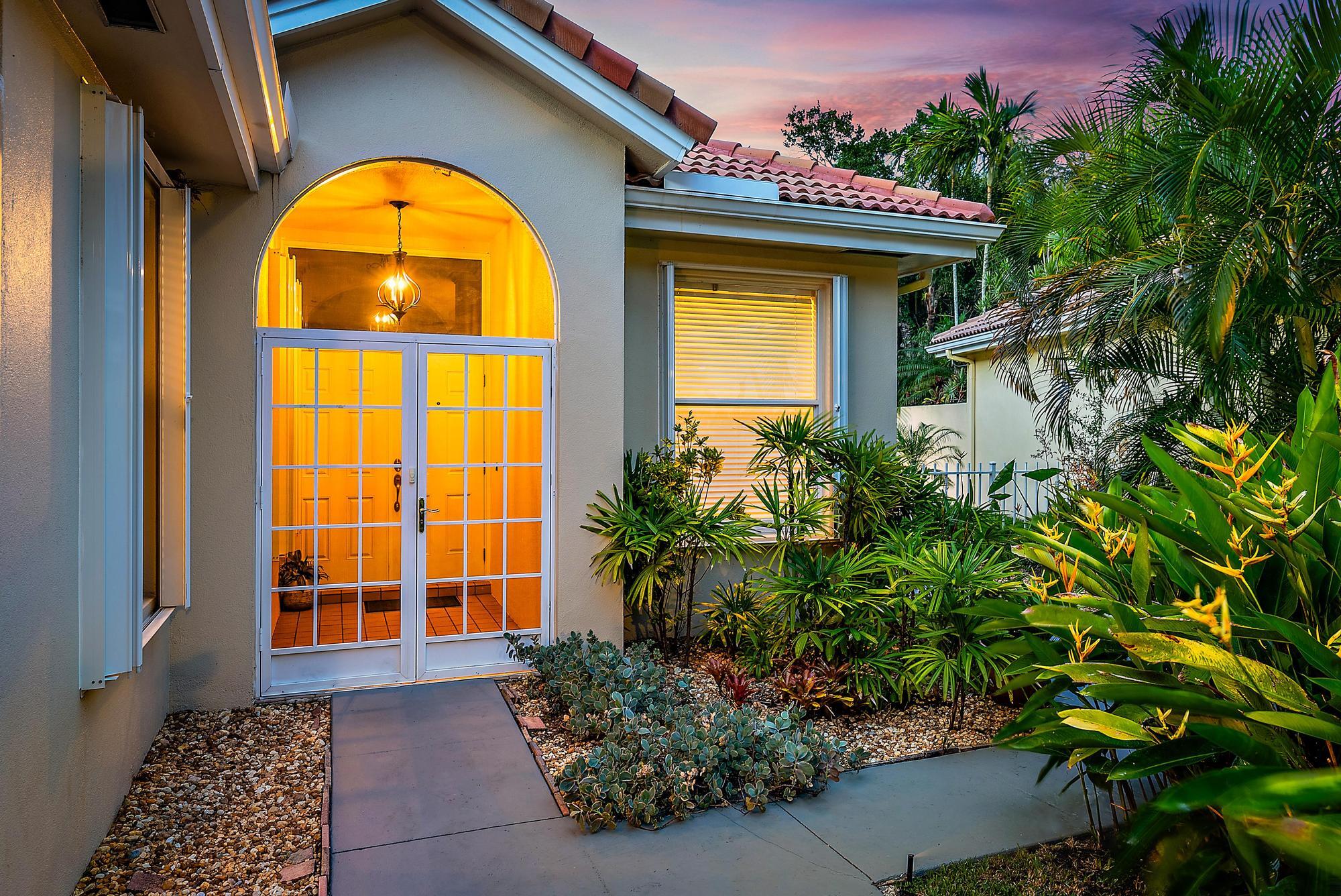 124 South Hampton Drive Jupiter, FL 33458 - Photo 23 of 39 a view of front door of house with potted plants