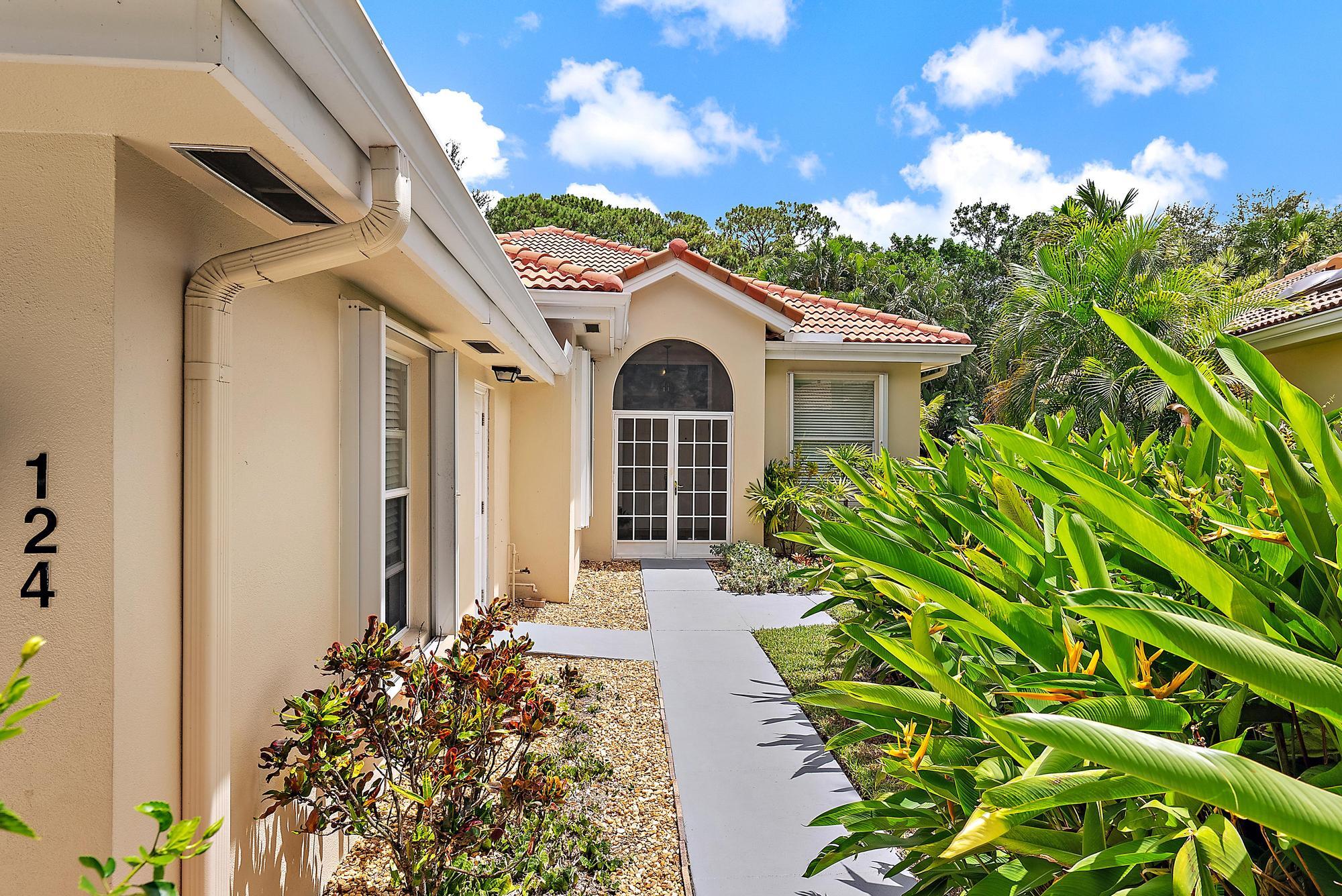 124 South Hampton Drive Jupiter, FL 33458 - Photo 29 of 39 a front view of a house with a garden