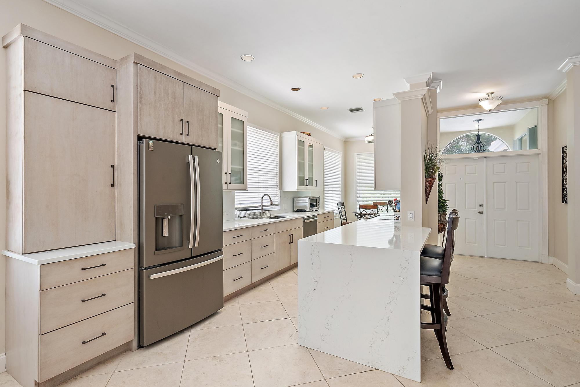 124 South Hampton Drive Jupiter, FL 33458 - Photo 5 of 39 a kitchen with stainless steel appliances a refrigerator sink and cabinets