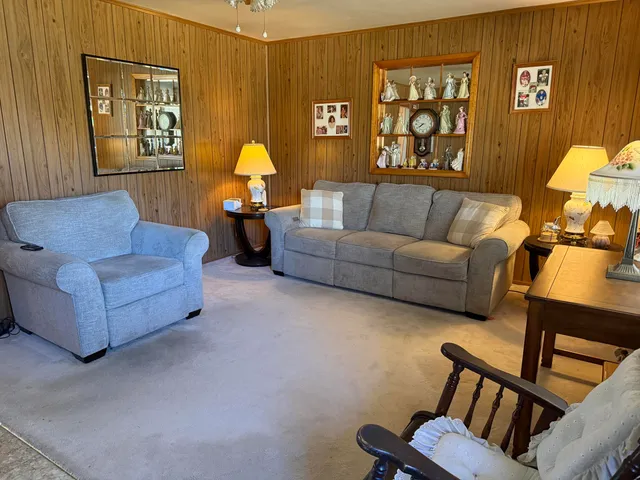 a living room with furniture a lamp and paintings on the wall
