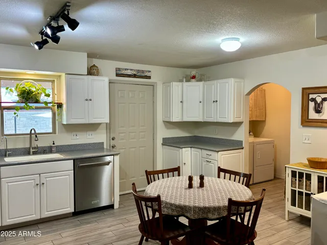 a kitchen with a table chairs sink and cabinets