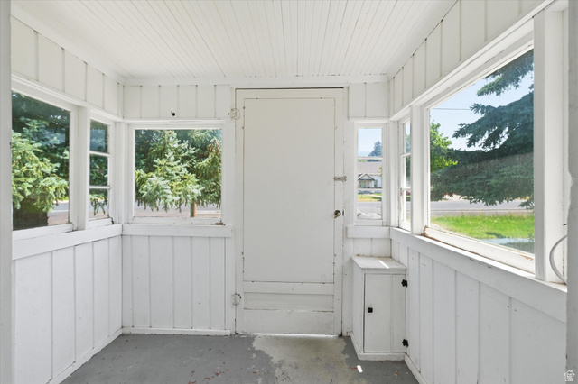 395 North 400 West Logan, UT 84321 - Photo 31 of 48 Enclosed porch with multiple windows, beadboard ceiling, white paneled walls, and built-in storage cabinet