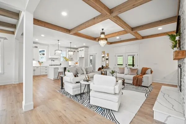 a dining room with wooden floor a chandelier a glass table and chairs
