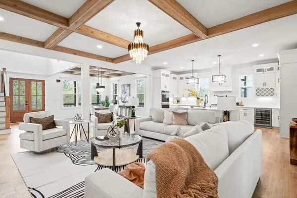 a kitchen with stainless steel appliances granite countertop a sink dishwasher and white cabinets with wooden floor